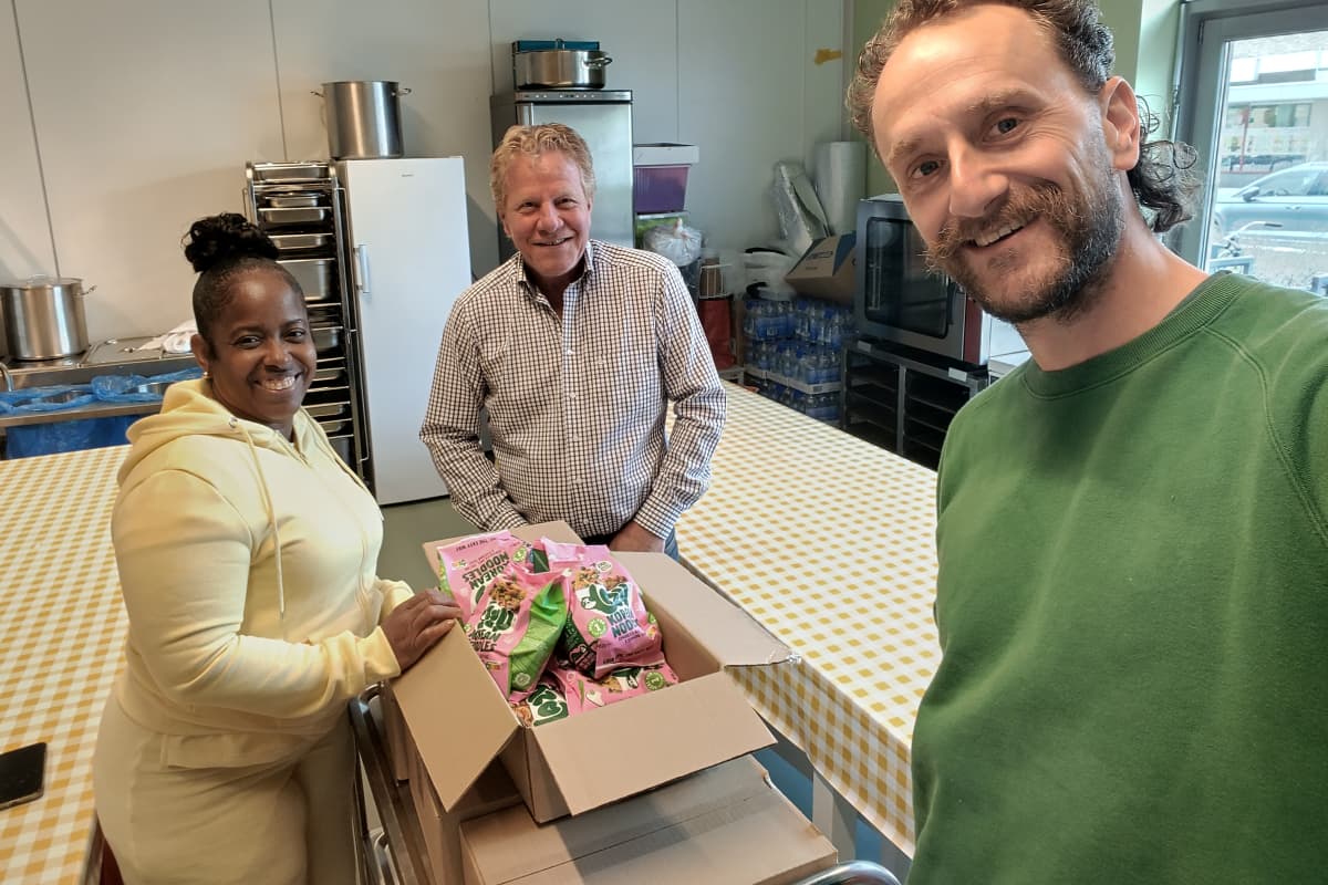 Vrijwilligers en een partner leveren Korean Noodles af in een buurthuis